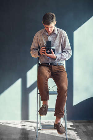 Portrait of handsome man with retro middle format camera in studio. Photographerの写真素材