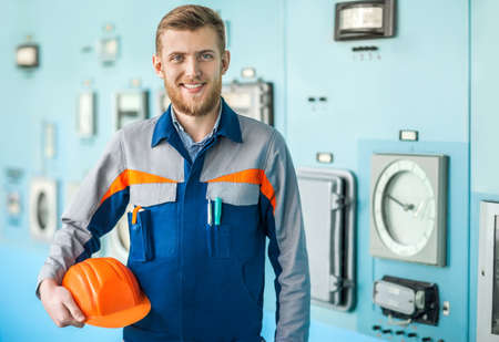 Portrait of young happy engineer in control room in factoryの写真素材