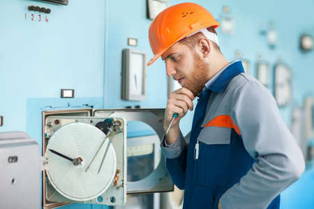 Portrait of young engineer repairing equipment at control room in factoryの写真素材