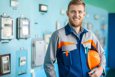 Portrait of young happy engineer in control room in factoryの写真素材