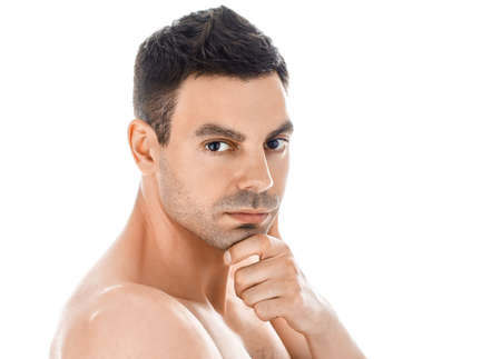 Portrait of young handsome man with healthy clean skin touching his chin isolated on white backgroundの写真素材