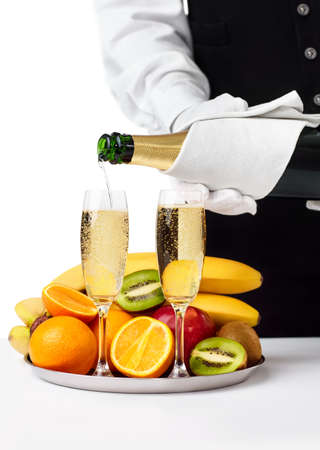 Waiter pouring champagne into glass isolated on white background. Romantic dinnerの写真素材