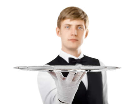Portrait of young handsome waiter holding empty tray isolated on white backgroundの写真素材