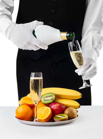 Waiter pouring champagne into glass isolated on white background. Romantic dinnerの写真素材
