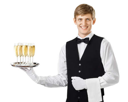 Portrait of young happy smiling waiter serving champagne on a tray isolated on white backgroundの写真素材