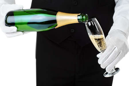 Waiter pouring champagne into glass isolated on white backgroundの写真素材