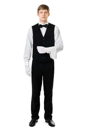 Full length portrait of handsome elegant waiter standing with towel over arm isolated on white backgroundの写真素材