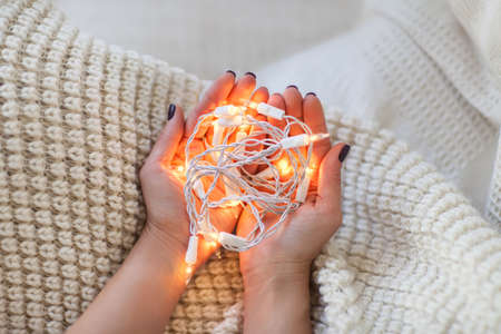 Woman holding christmas light in hand. New Year conceptの写真素材