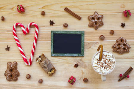 Christmas cookies and blackboard with festive decoration on wooden background. Top viewの写真素材