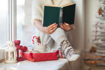 Woman reading book in christmas decorated home. Holiday conceptの写真素材