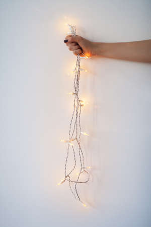 Christmas lights in hand on white backgroundの写真素材