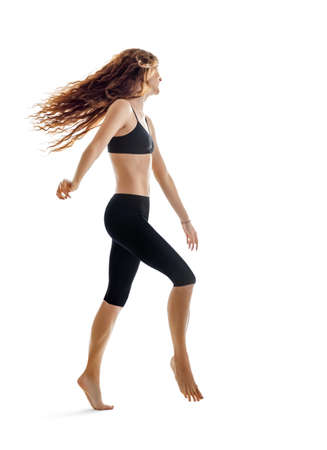 Happy jumping dancing girl with flying hair isolated on white backgroundの写真素材