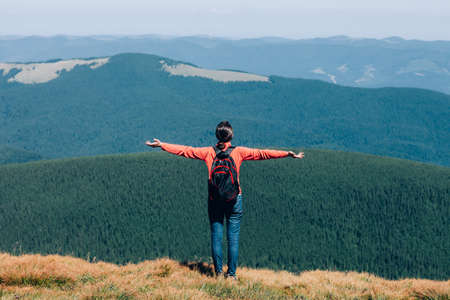 Freedom young girl with hands up in mountains.の写真素材
