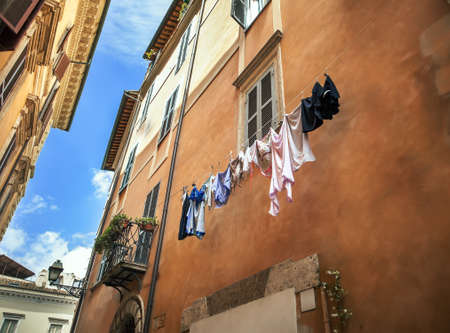Traditional narrow street and old houses with washing hanging on a line in Rome, Italyの写真素材
