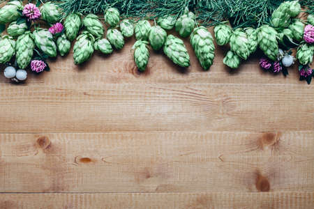 Flowers frame of hop twig and clover on wooden background with copy spaceの写真素材