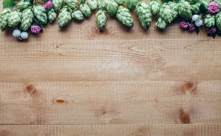 Flowers frame of hop twig and clover on wooden background with copy spaceの写真素材