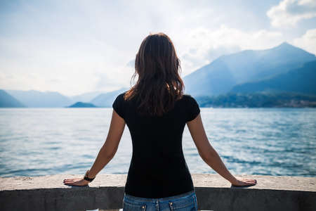 Back view of young woman relaxing on terrace on lake Como, Italy.の写真素材