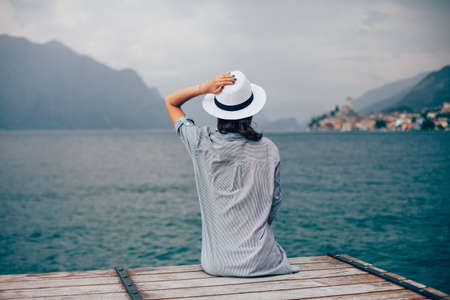 Beautiful woman relaxing on pier in Garda Lake. Vacation conceptの写真素材