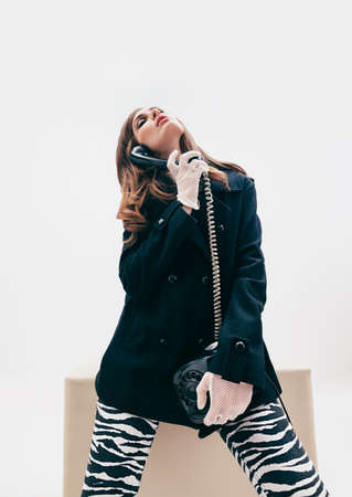 Emotional beautiful woman with telephone in retro style on white backgroundの写真素材