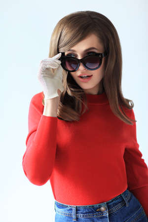 Fashion retro style portrait of young beautiful woman in sunglasses on white backgroundの写真素材