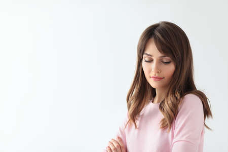 Beautiful shy woman portrait with copy space on white backgroundの写真素材
