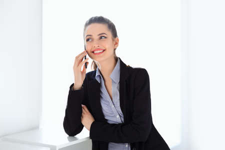 Beautiful smiling business woman speaking on mobile phoneの写真素材