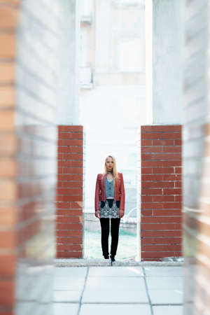 Full length portrait of young pretty woman standing in abstract architecture building. Urban conceptの写真素材