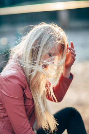Young beautiful blonde woman with wind in hair. Emotional art portraitの写真素材