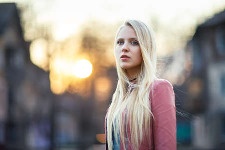Portrait of young beautiful blond woman in the street on sunsetの写真素材