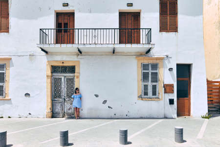 Young beautiful woman on traditional greek house backgroundの写真素材