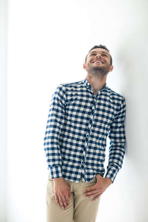 Handsome laughing man in stylish casual clothes leaning at white wall
の写真素材