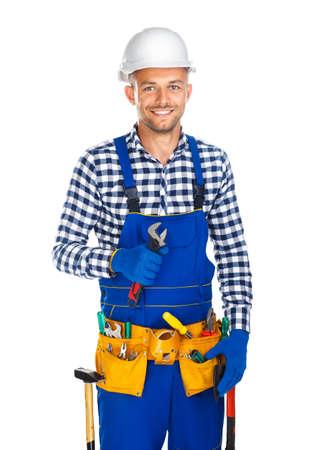 Happy smiling construction worker with wrenchand tool belt isolated on white backgroundの写真素材