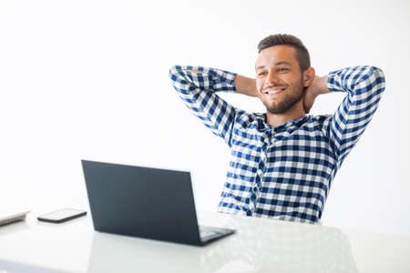 Relaxed happy man sitting with laptop on white backgroundの写真素材