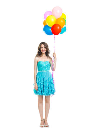 Happy beautiful woman in blue dress holding colorful balloons isolated on white background. Full length portraitの写真素材