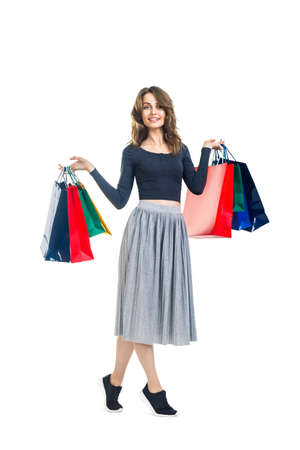 Happy beautiful woman holding many colorful shopping bags isolated on white background. Full length portraitの写真素材