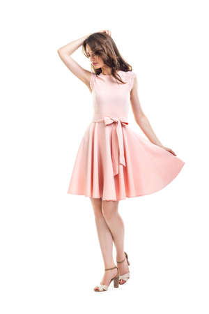 Full length portrait of happy beautiful woman in pink dress posing in studio isolated on white backgroundの写真素材