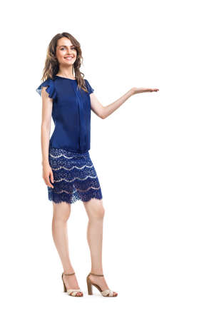 Young beautiful woman presenting with copy space isolated on white background. Full length portraitの写真素材