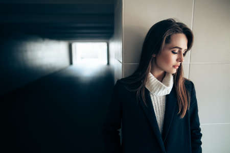 Beautiful lonely woman in a subway tunnel. Light at End of Tunnelの写真素材