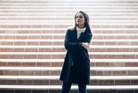 Sensual beautiful woman standing alone on underground stairs with copy space