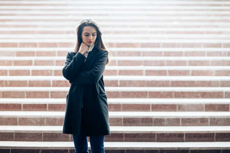 Sensual beautiful woman standing alone on underground stairs with copy spaceの写真素材