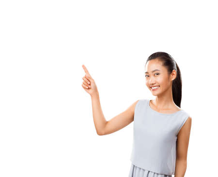 Young beautiful asian woman pointing finger isolated on white background with copy space. Concept photography for training, business, advertising, beauty projectsの写真素材