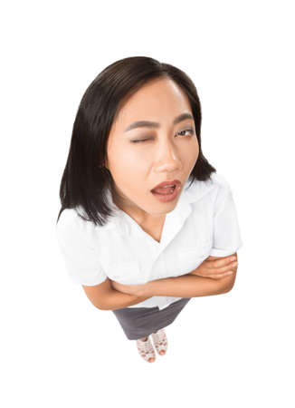 Top view portrait of Asian woman with facial expressions - apathy, fatigue, mannerisms concept. Model in full length with one closed eye and open mouth isolated on white backgroundの写真素材