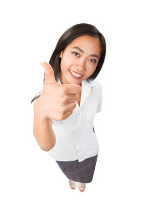 Top view portrait of smiling asian woman thumbs up. Female model in full length isolated on white background. Beautiful success businesswoman. Approval, agree, praise concept. Photo focus on the handの写真素材