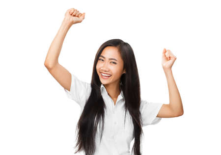 Happy young oriental woman dancing or rejoicing. Portrait of cheerful smiling Asian girl with hands up. Joyful emotions, victory, entertainment concept photo isolated on white backgroundの写真素材