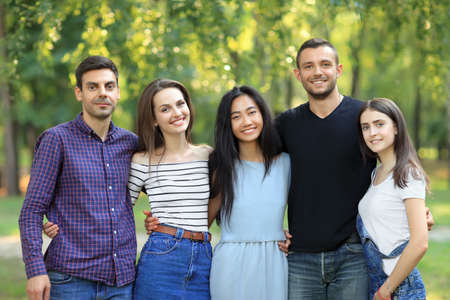 Five women and men friends on green forest background. Half body portrait of multi racial friends in park on summer sunny day. Beautiful happy carefree people, friendship conceptの写真素材