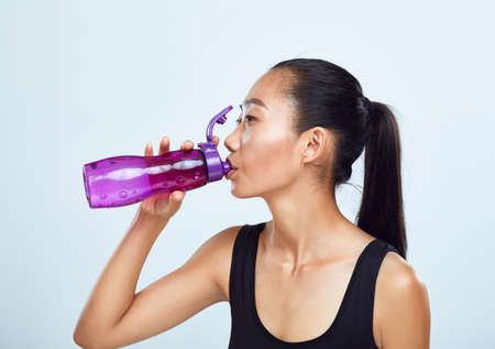 Young sports woman drinks bottled water. Sports lifestyle, fluid replenishmentの写真素材