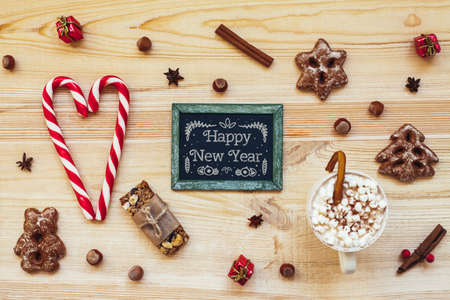 Christmas cookies and blackboard with festive decoration on wooden background. Top viewの写真素材