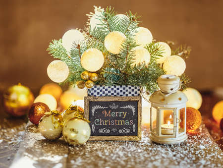 Christmas decoration with baubles, lantern and text on wood boardの写真素材