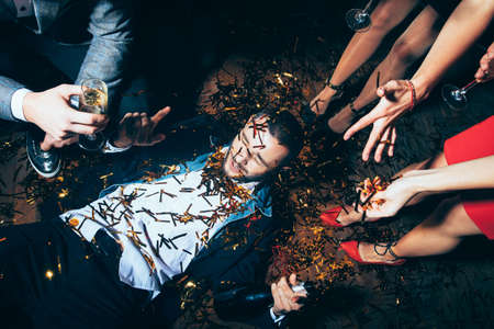 Crazy party. Drunk man lying on floor. New year, Birthday, Holiday Event conceptの写真素材