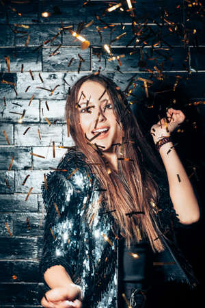 Young beautiful woman dancing in confetti and enjoying party. Happiness. New year, Birthday, Holiday Event conceptの写真素材